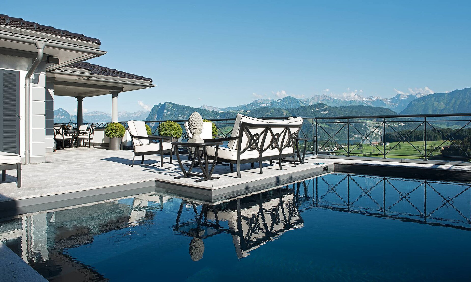 Exquisit: Terrasse mit Pool und Blick auf See und Berge.