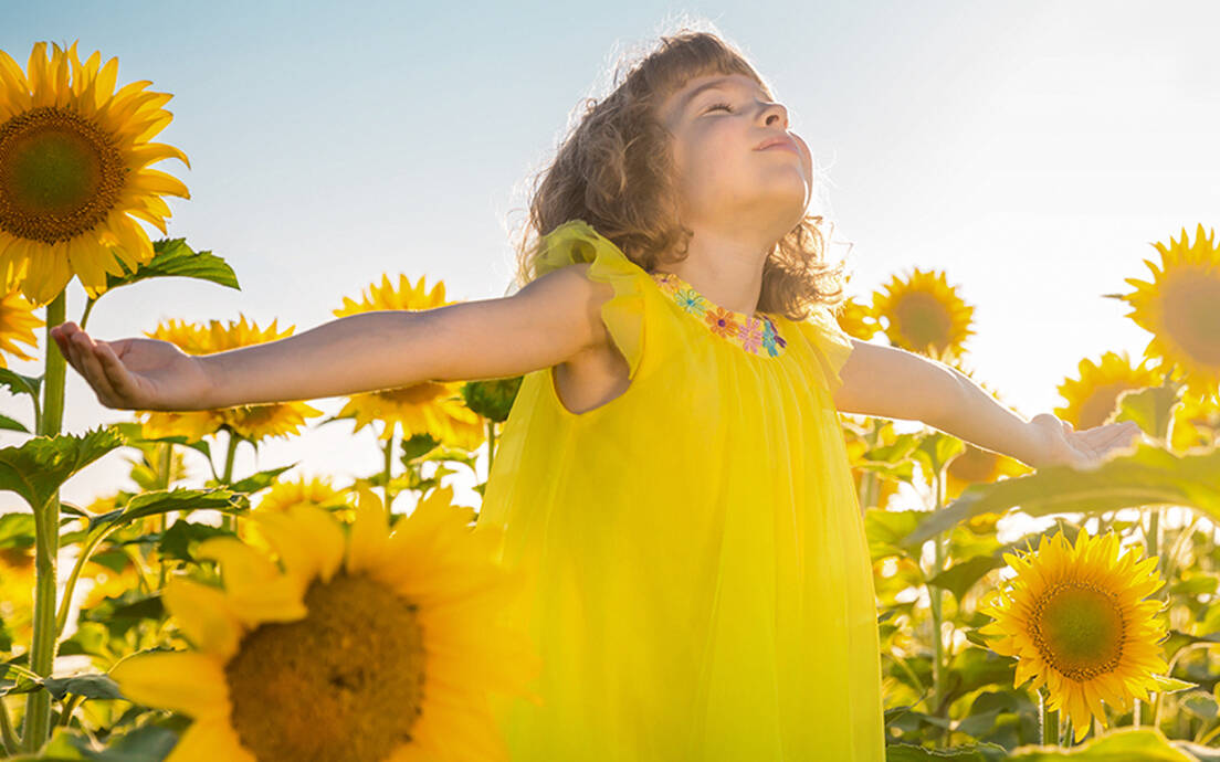 Energieeffizienz Kind, Mädchen im Sonnenblumenfeld, Sommerfest