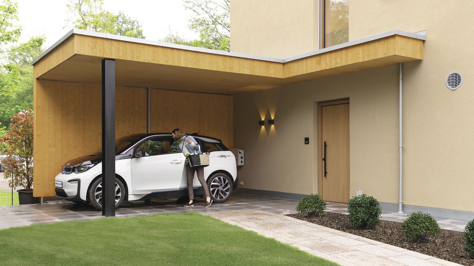 Ausstellungshaus sunshine mit holzverschaltem Carport und E-Ladestation Carport mit E-Ladestation