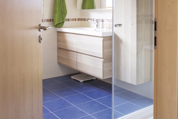Bad und Dusche mit blauen Bodenfliesen Bad und Dusche mit blauen Bodenfliesen