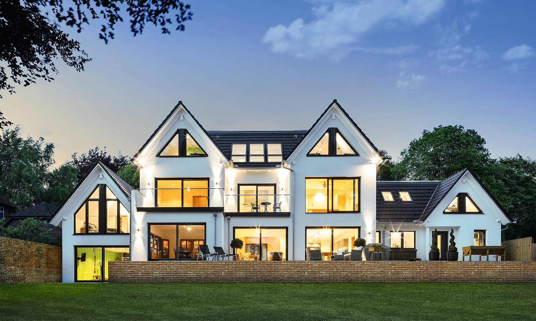 Haus mit großer Fensterfront in Abendstimmung