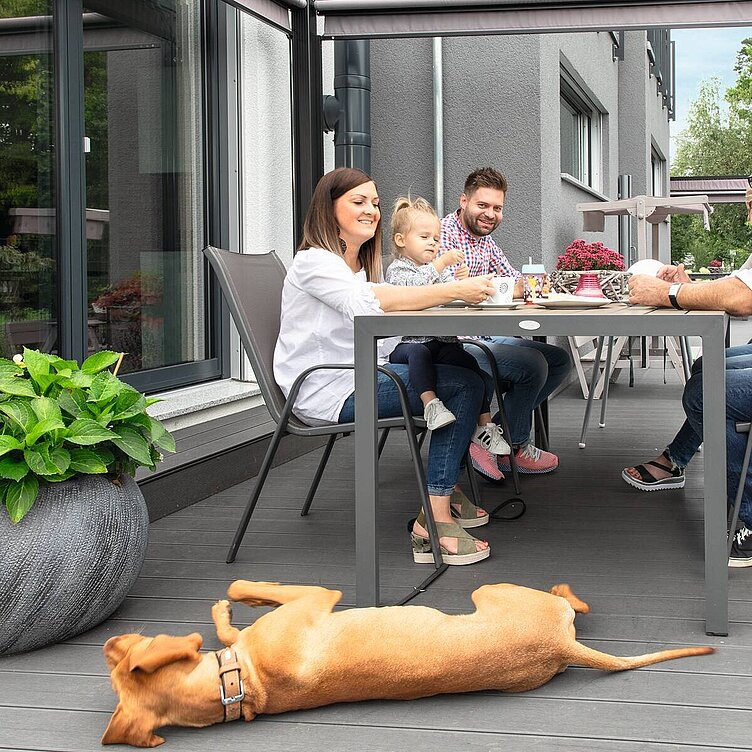 Familie mit Hund auf der Terrasse