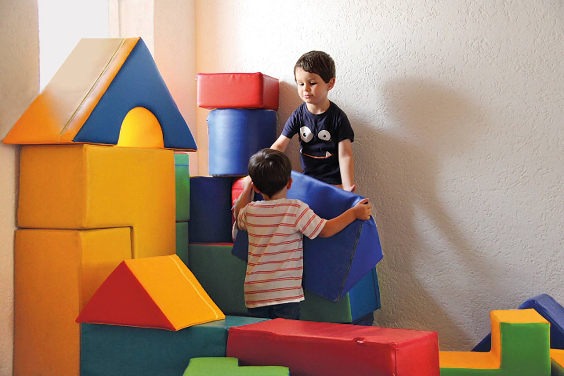 Kinder spielen mit Schaumstoff Bausteinen