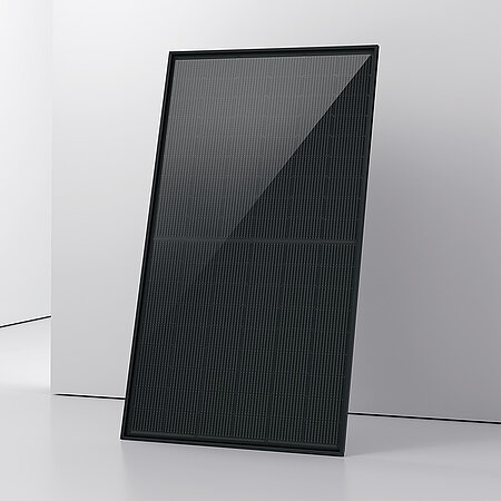 Ein aufrecht stehendes schwarzes PV-Modul mit einem strukturierten, glänzenden Oberflächenfinish. Es steht in einem hellen Raum mit glatten Wänden und einem weißen Boden. 